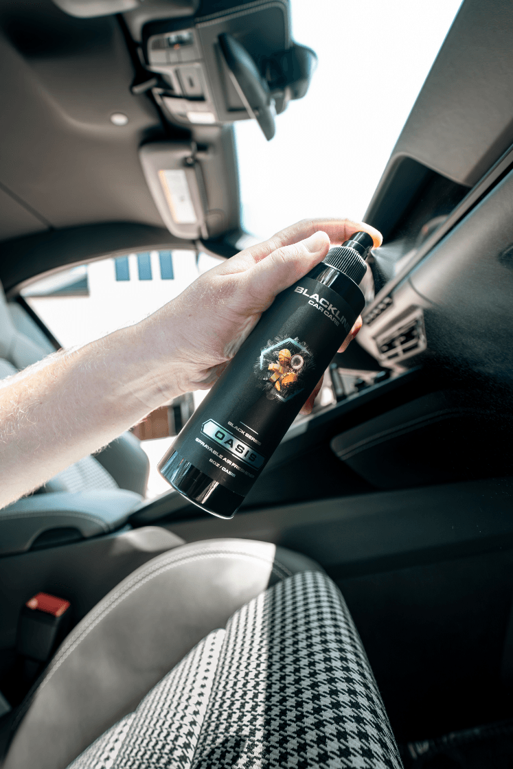 Person holding a bottle of hair product inside a car