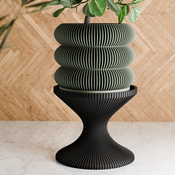 Black ribbed planter with a plant on a wooden surface