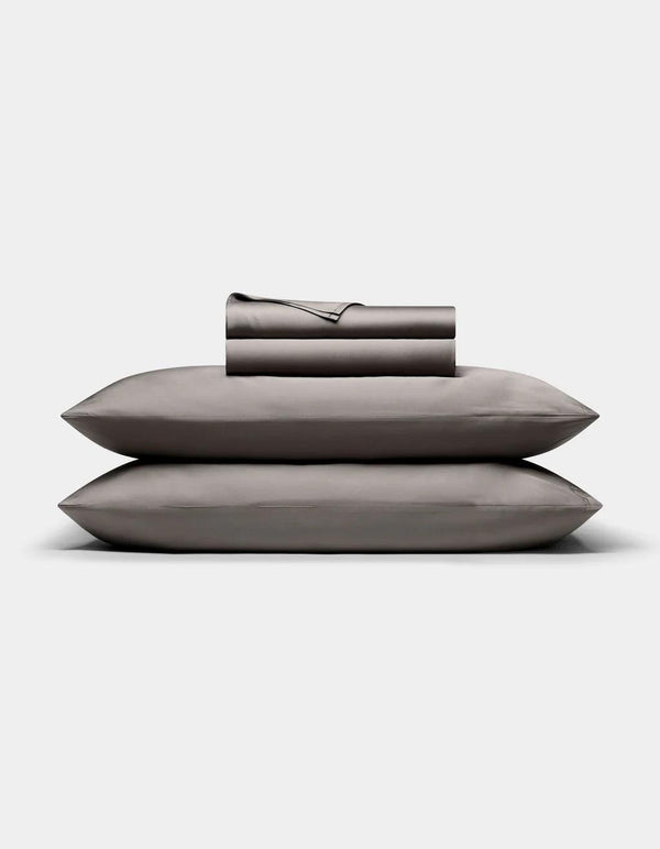 Set of Charcoal pillows and a folded blanket on a light gray background