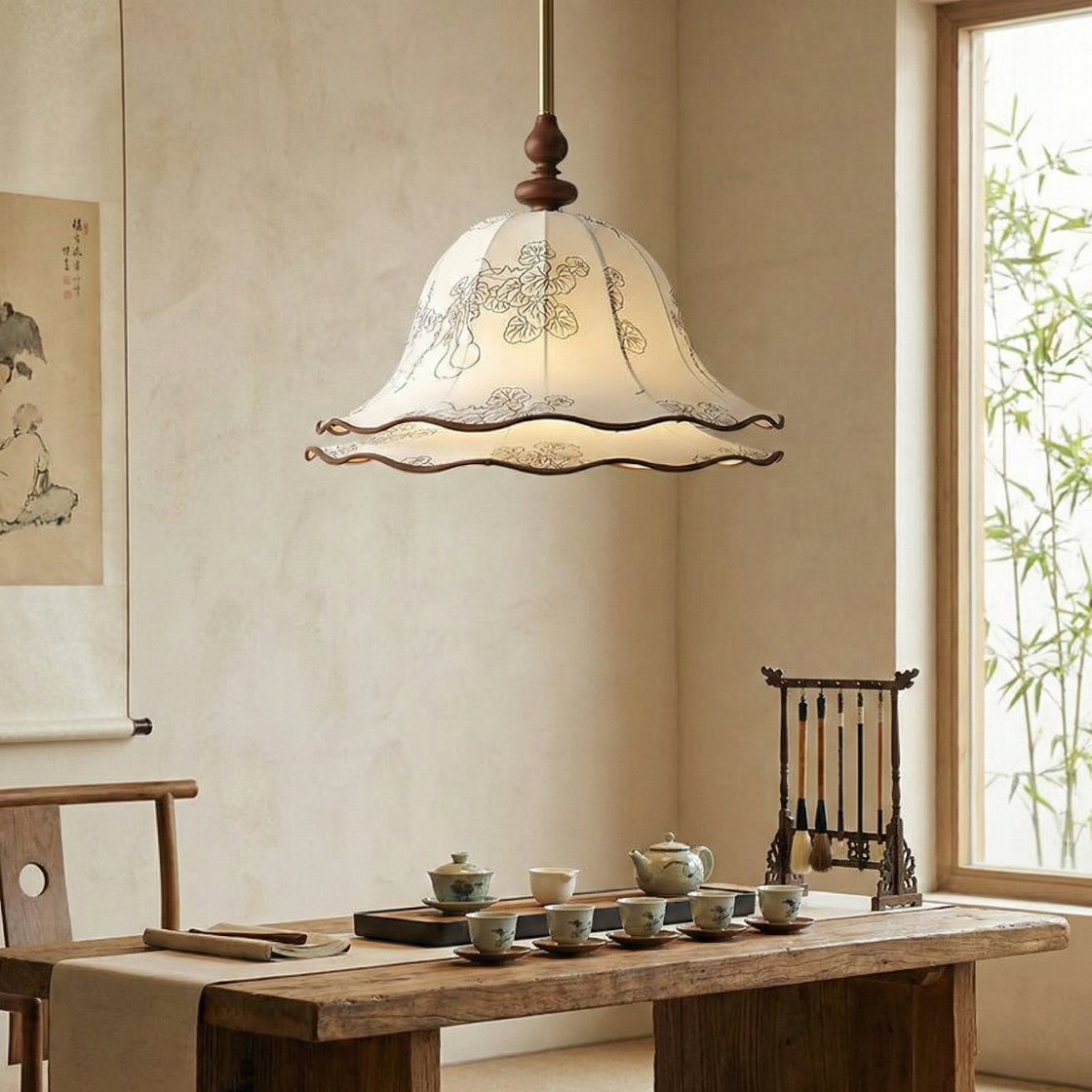 Traditional Chinese-style pendant light hanging above a wooden table with tea set.
