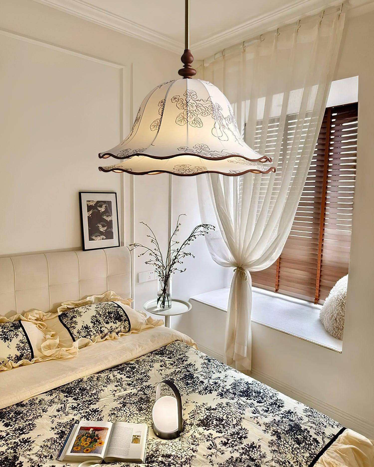 Decorative pendant light hanging above a bed in a bedroom with a window and curtain.