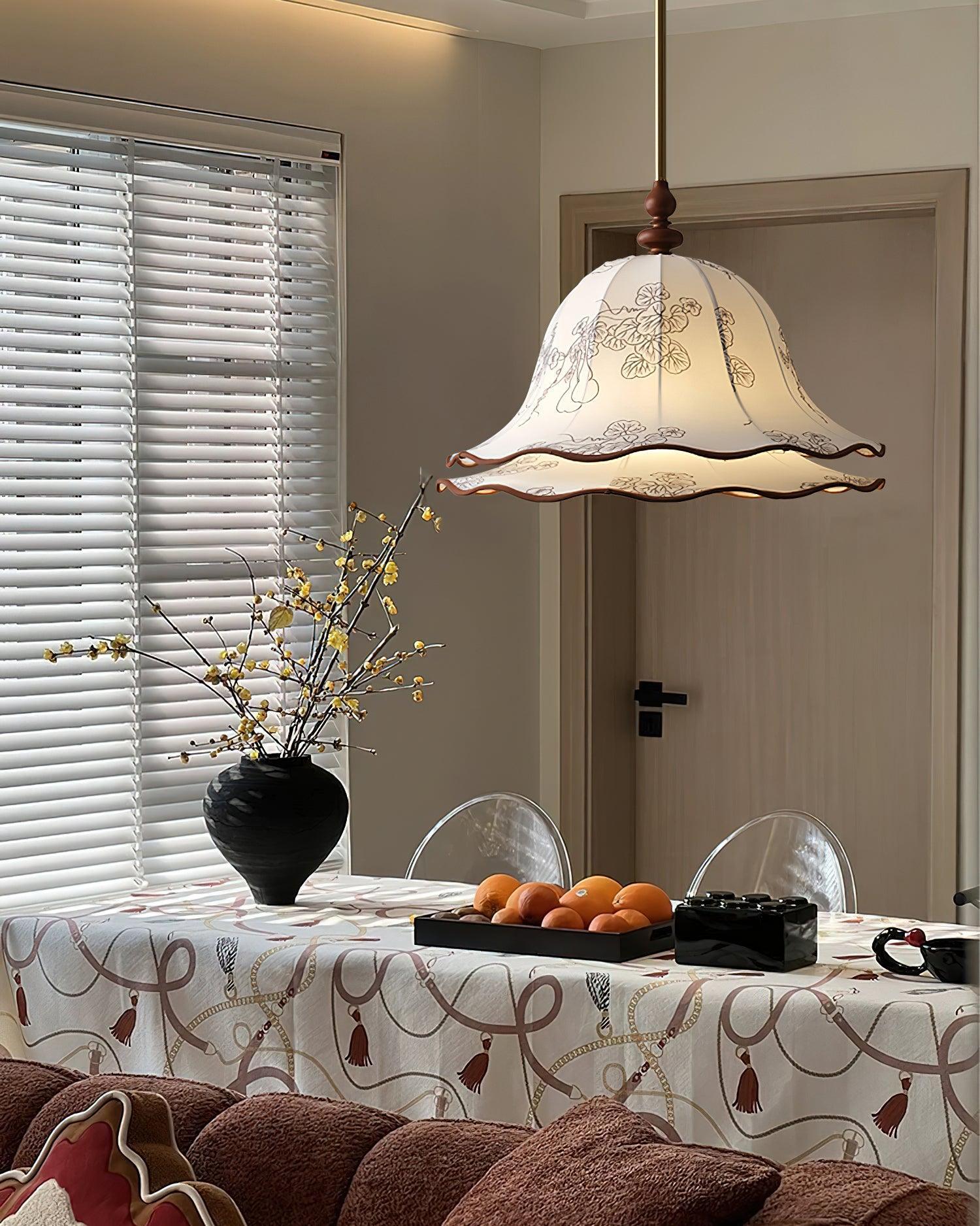 Dining room with a table set for a meal, featuring a decorative pendant light.