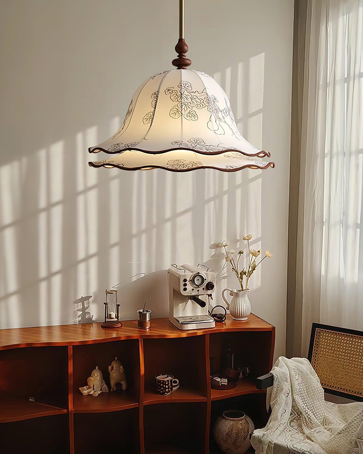 Decorative pendant light hanging above a wooden desk with various items.
