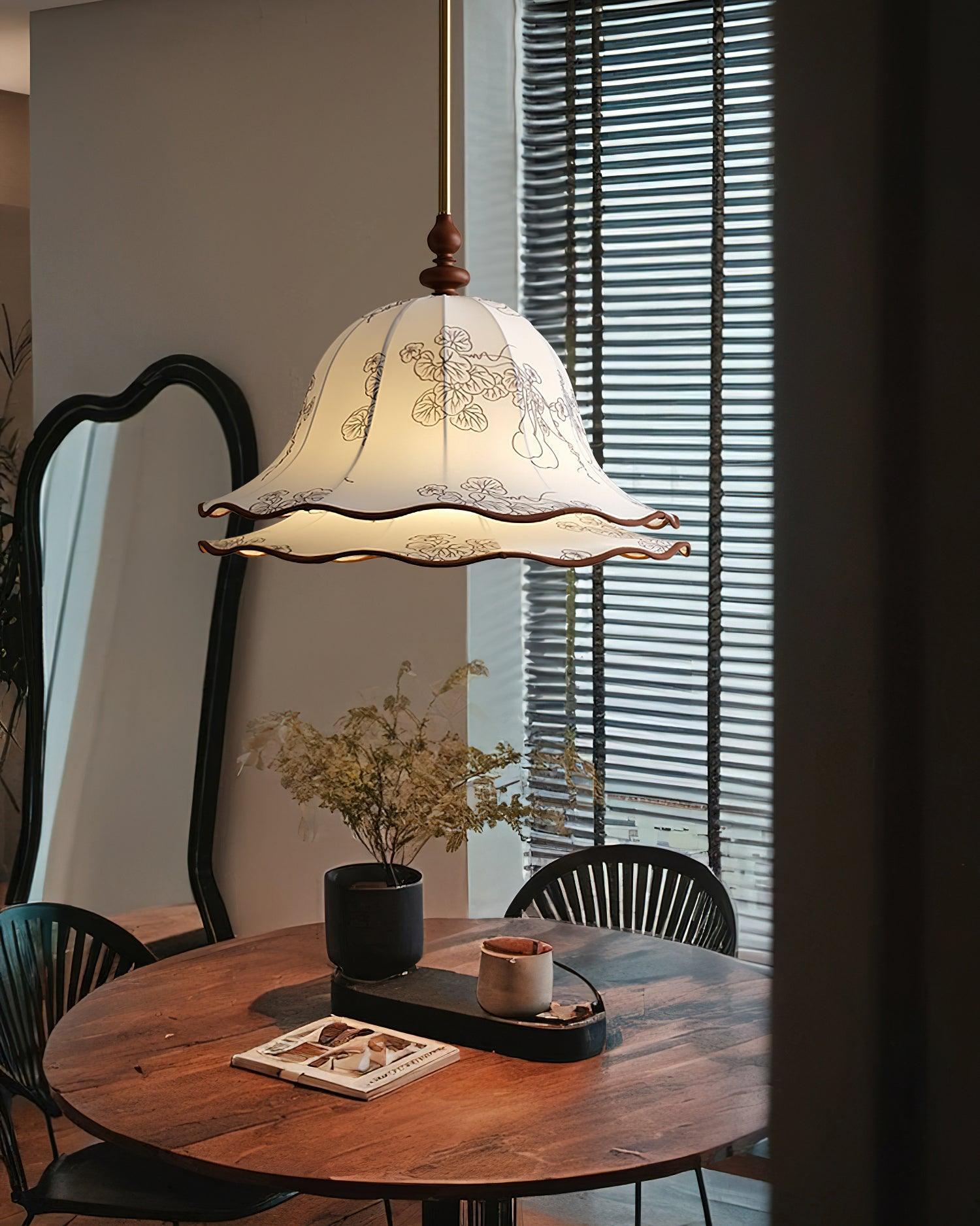 Pendant light hanging above a wooden table with decor items in a room.