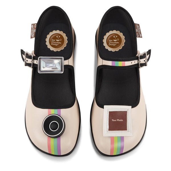 Chocolaticas® Instant Memories  Women's Mary Jane Flat - Pair of black and beige shoes with rainbow stripes on a white background