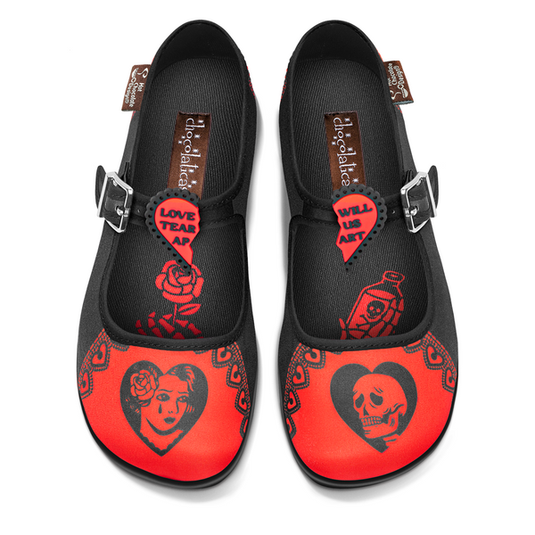 A pair of women's flat shoes with a black and red design featuring text and heart motifs, along with a skull and floral elements.