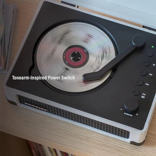 Turntable with a tonearm-inspired power switch on a wooden surface