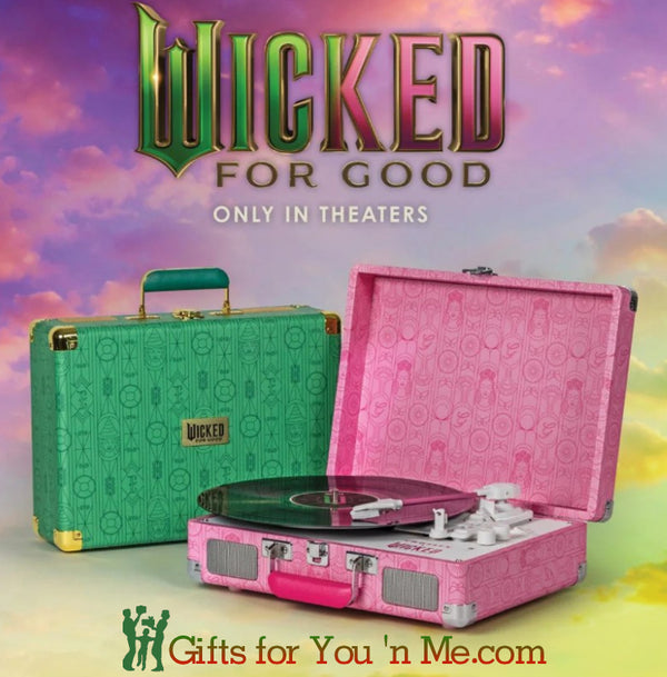 Crosley X Wicked for Good Pink record player case and green suitcase with 'Wicked' branding against a colorful sky background at Gifts for You 'n Me