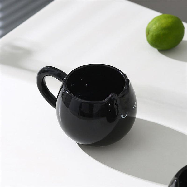 Adorable hand - painted cat - shaped ceramic mug, perfect for coffee or tea.