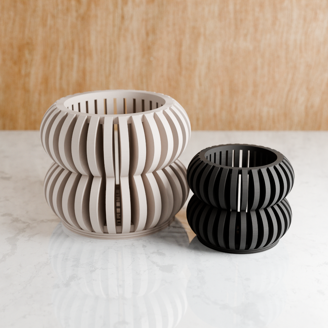 Two ceramic candle holders, one beige and one black, on a marble surface with a wooden background.