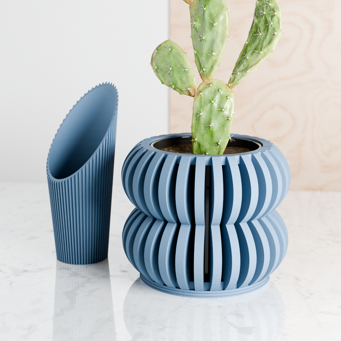 Blue ribbed plant pot with a cactus on a light surface