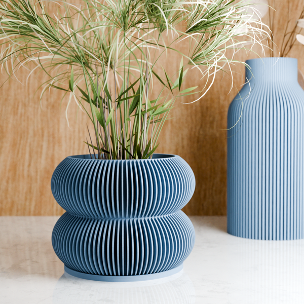 Blue textured vases with a plant on a wooden surface