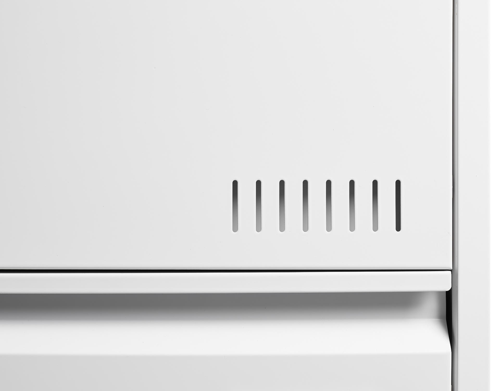 Close-up of a white appliance with a metallic vent on a white background