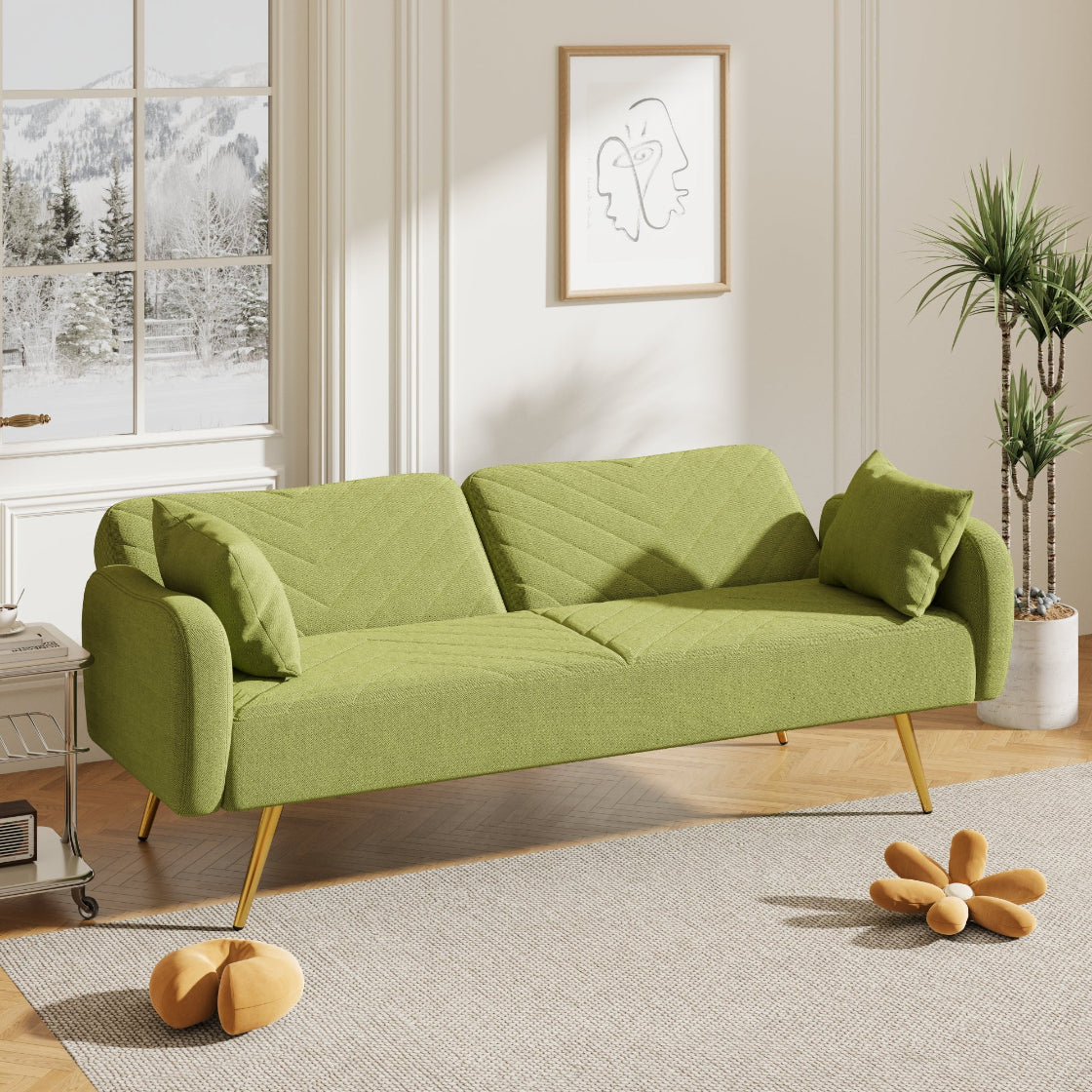 Green sofa in a living room with a window and decorative items.