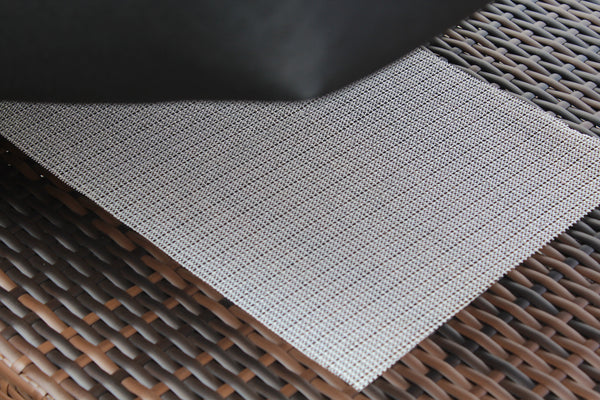 Gray textured mat on a woven surface