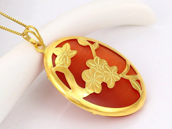 Oval shaped rust-red color noble charms pendant with gold flowers