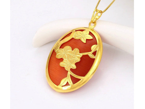 Oval shaped rust-red color noble charms pendant with gold flowers