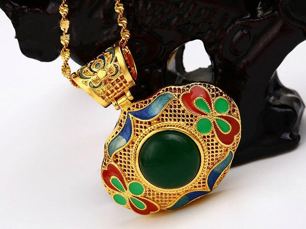 Leaf shaped gold pendant with green and red enamel work