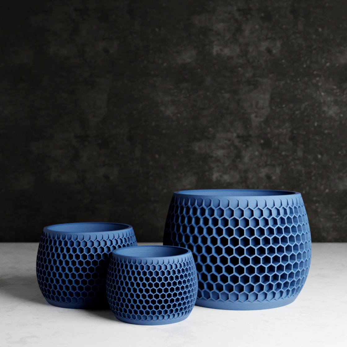 Three blue textured ceramic pots on a dark background