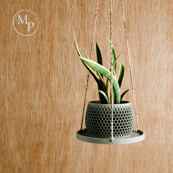 Hanging planter with a textured pot on a wooden background