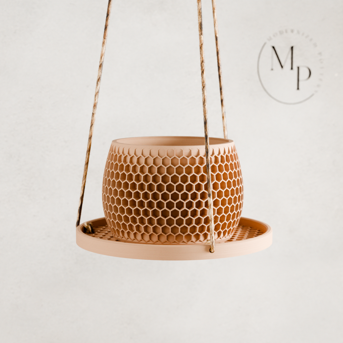 Hanging ceramic planter with honeycomb pattern on a white background