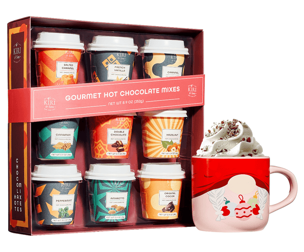 Box of gourmet hot chocolate mixes with a pink mug featuring a cartoon face.