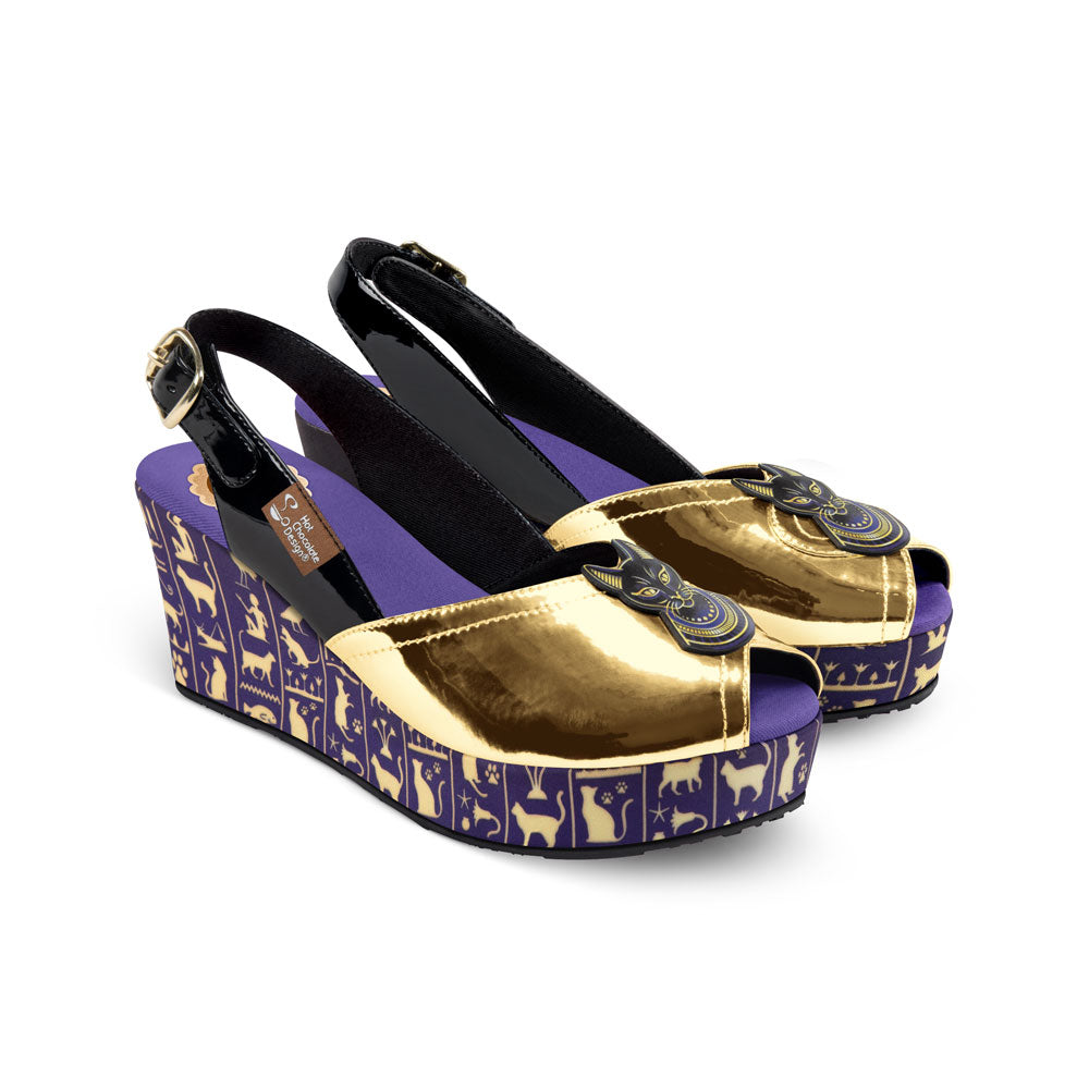 Hot Chocolate Design
Chocolaticas® Bastet Mid Women's Sandal - Gold and purple wedge shoes with decorative patterns on a white background