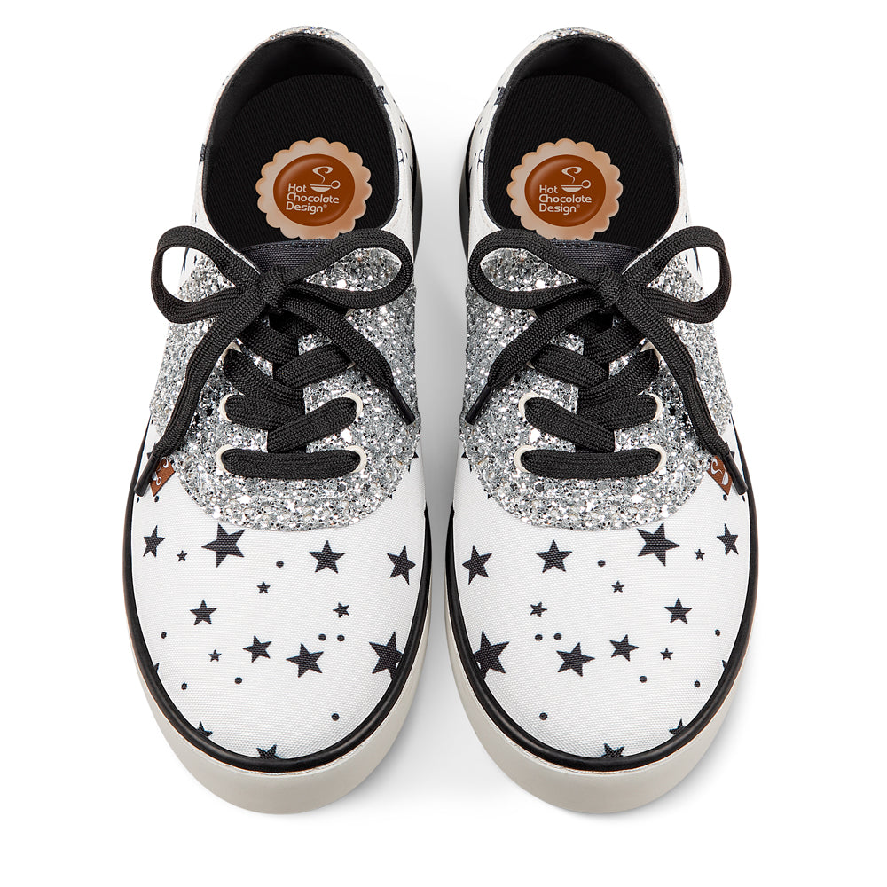 Hot Chocolate Design White sneakers with black star patterns and glittery accents on a white background