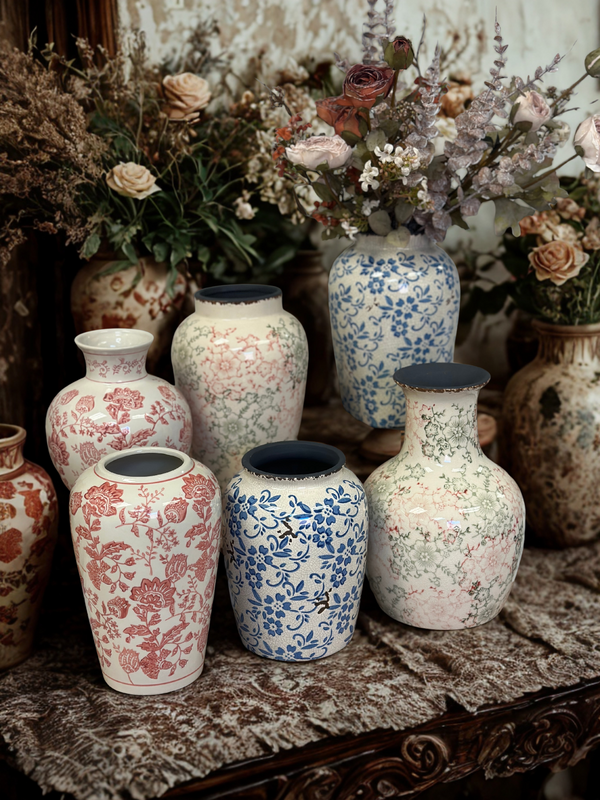 Collection of decorative vases with floral patterns on a textured surface