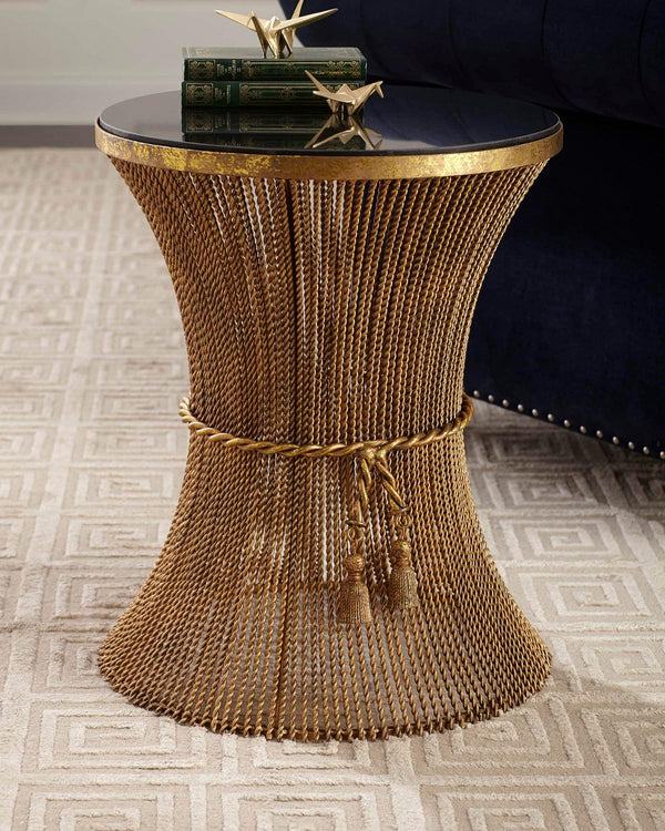 Gold chain side table with a black top on a patterned carpet