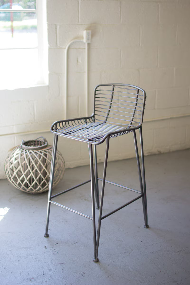 Kalalou Set of 2 - METAL BAR STOOL CHW1008. Metal bar stool in a room with a textured wall and decorative item on the floor.