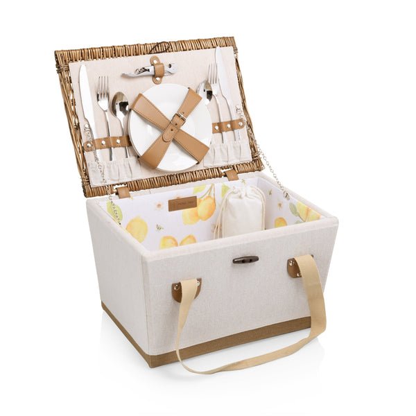 Open picnic basket with cutlery, plates, and a blanket on a white background