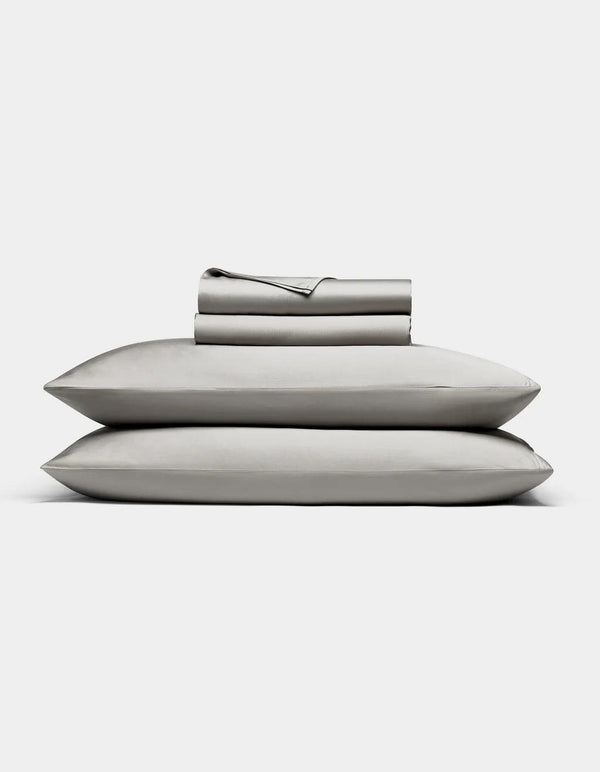 Light Grey bedding including a duvet, two pillows, and a folded blanket on a white background.