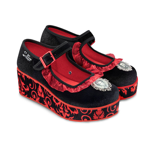 Black and red platform shoes with decorative patterns and buckles on a white background