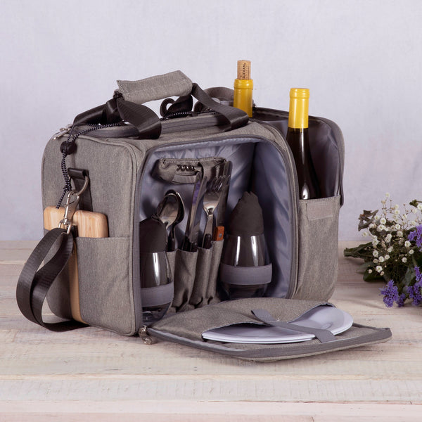 Gray picnic bag with cutlery, plates, and bottles on a wooden surface.