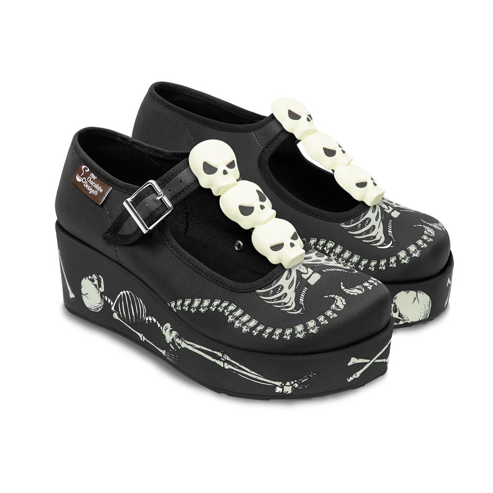 Black platform shoes with skeleton design and skull embellishments on a white background