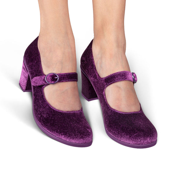Purple velvet shoes with a block heel on a white background