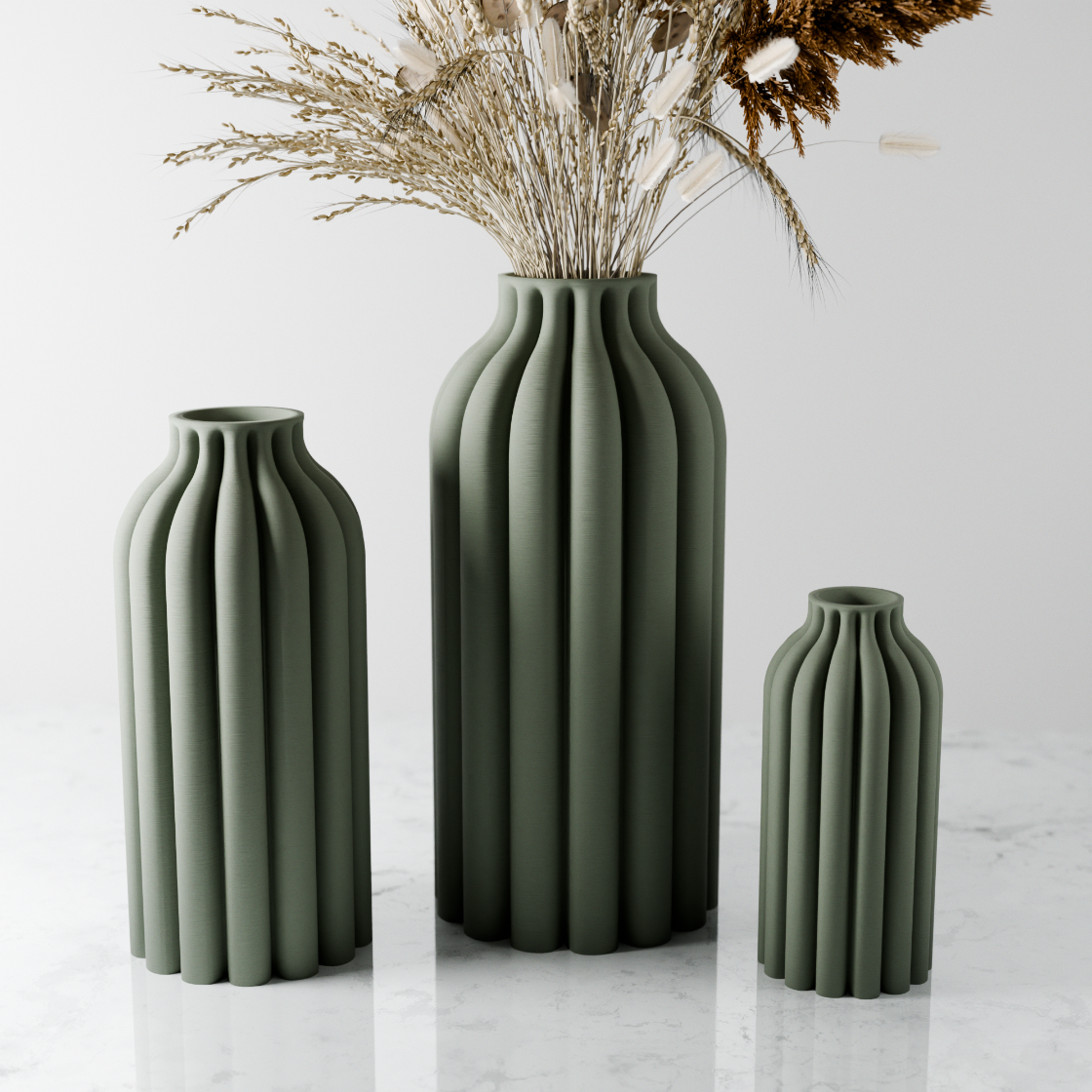 Three green vases of different sizes on a light gray background