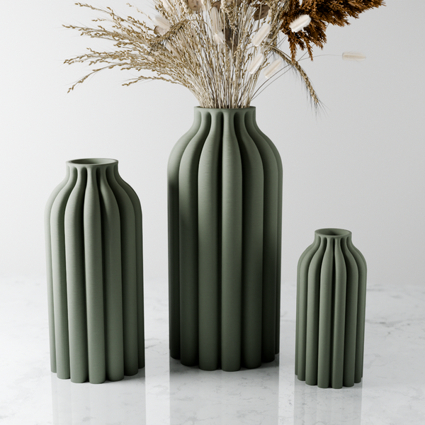 Three green vases of different sizes on a light gray background
