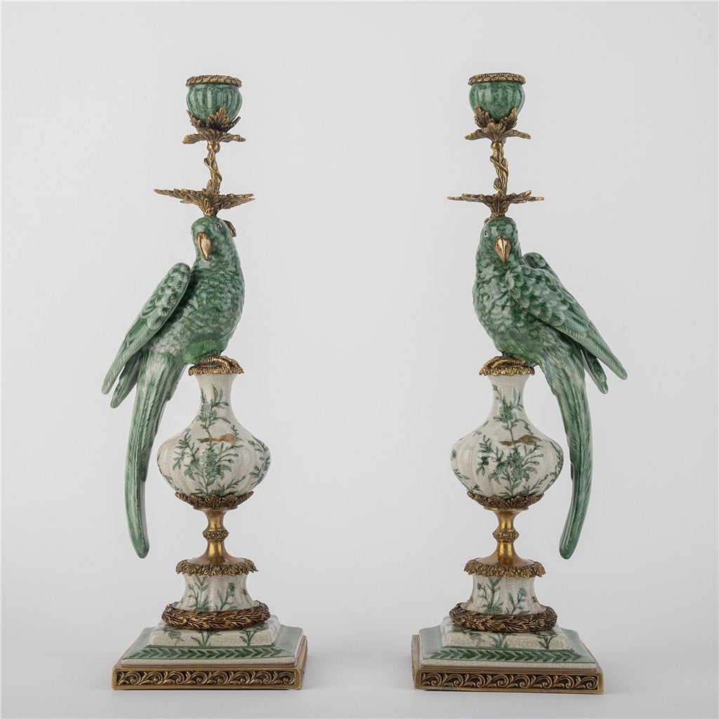 Pair of decorative candle holders with parrot designs on a white background