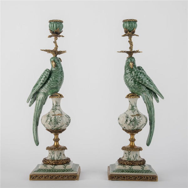 Pair of decorative candle holders with parrot designs on a white background