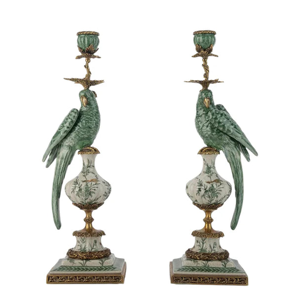 Pair of decorative candle holders with parrot figures on a white background