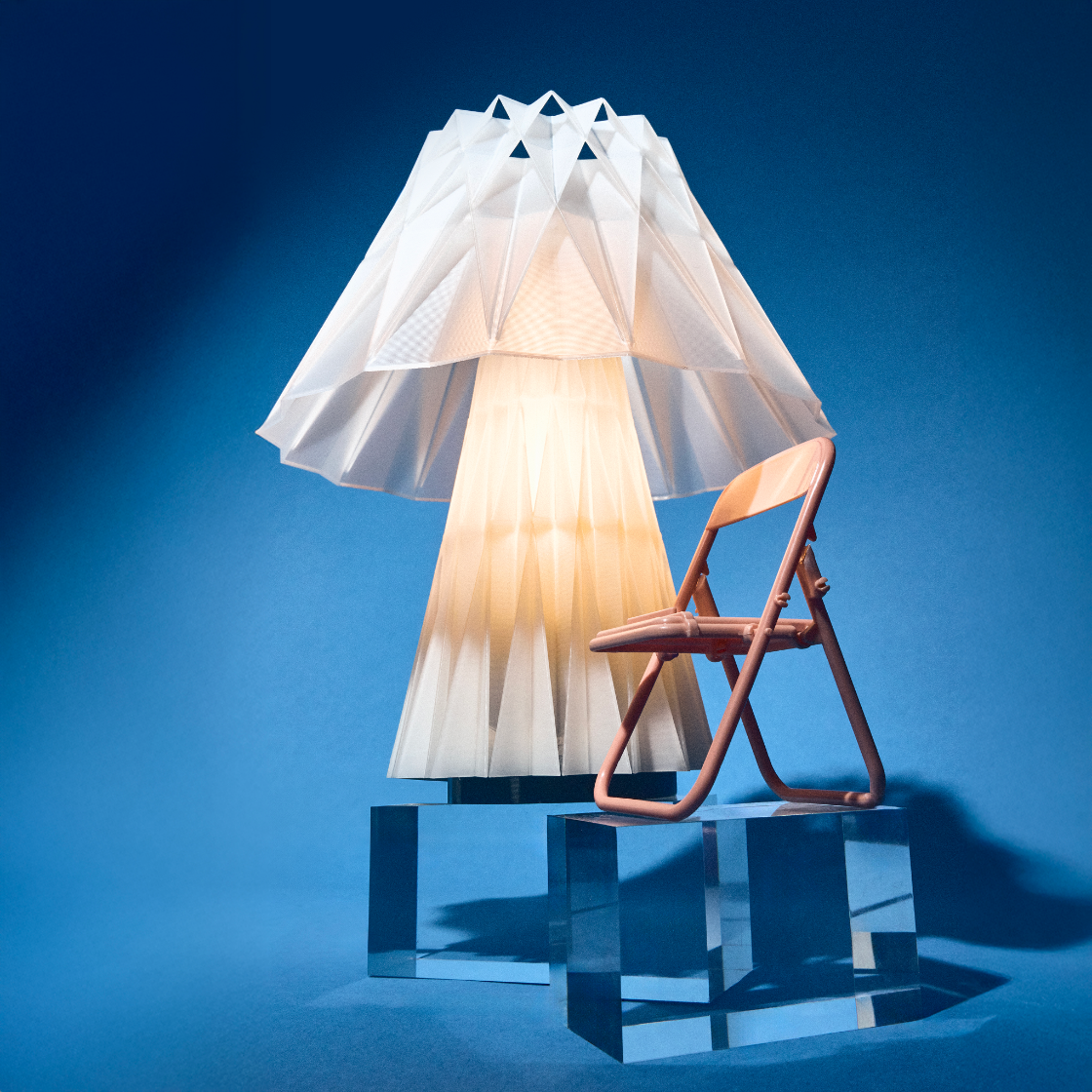 Modern lamp with a unique design on a clear base against a blue background
