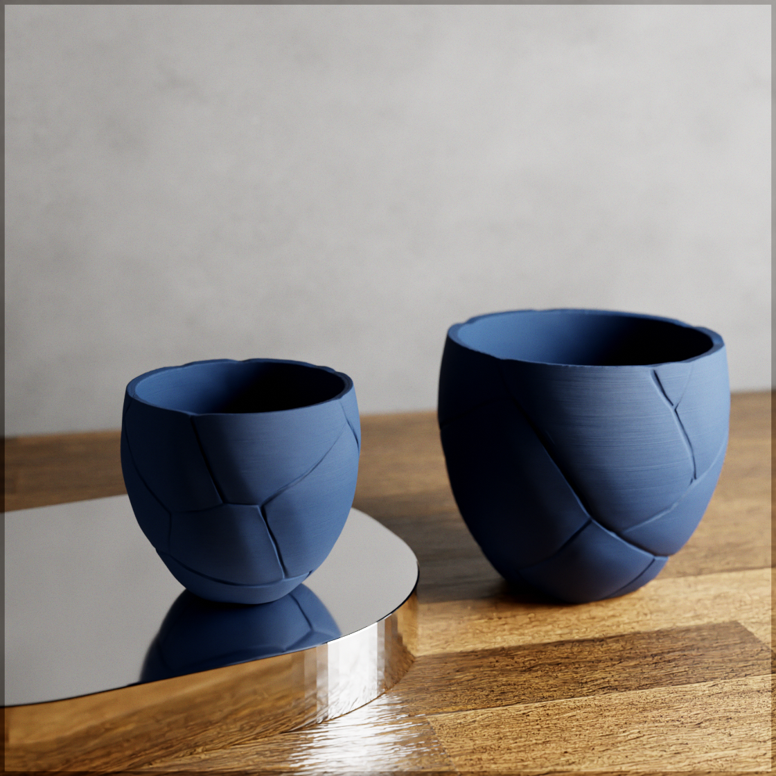 Two blue woven ceramic cups on a wooden surface with a gray background