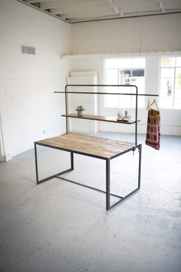 Modern metal and wood desk in a minimalistic room with large windows.