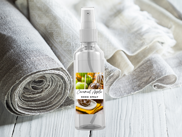 Room spray bottle with a label featuring apples and cinnamon on a textured fabric background