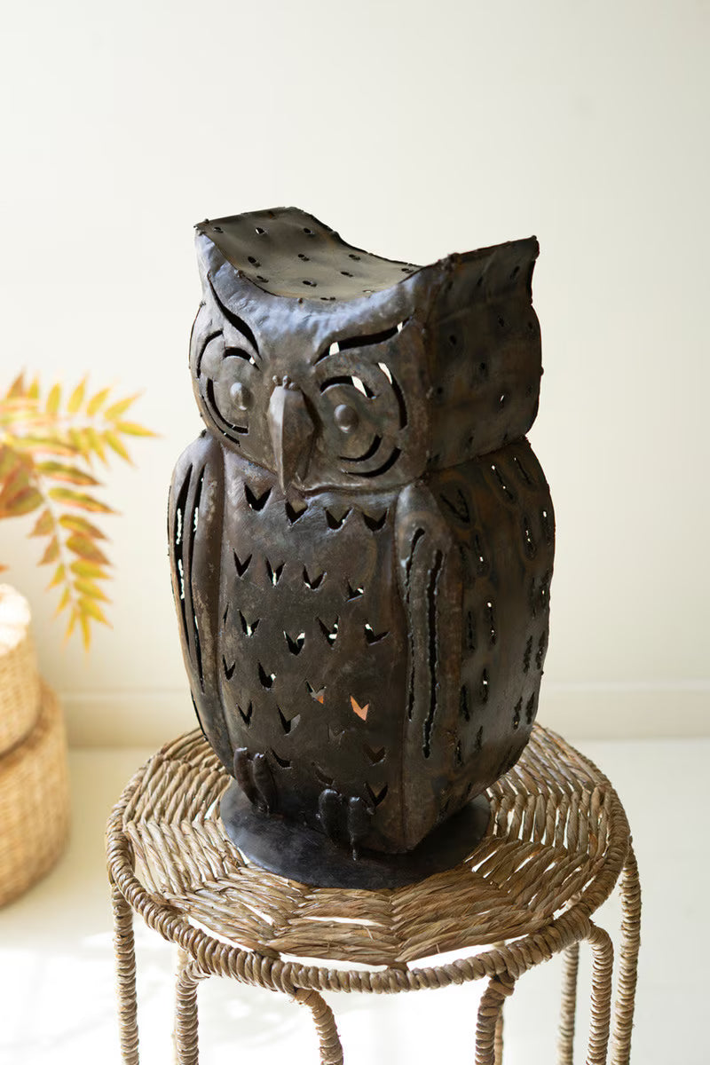 Decorative owl-shaped lantern on a small stool with a white background