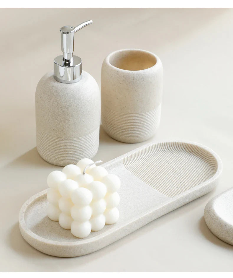 Modern beige bathroom set by Buddify featuring soap dispenser, tumbler, and tray with decorative candle from 5Pcs Bathroom Accessories set.