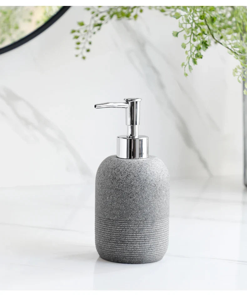 Grey soap dispenser with chrome pump from Buddify's 5Pcs Bathroom Accessories set, perfect for minimalist bathroom decor.