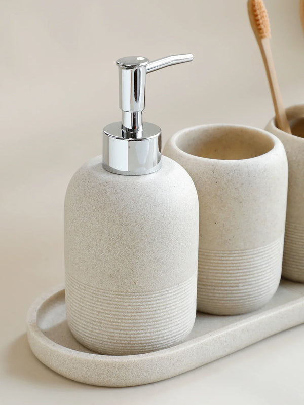 Beige soap dispenser with chrome pump from Buddify's 5Pcs Bathroom Accessories set, displayed with tumbler on matching tray.